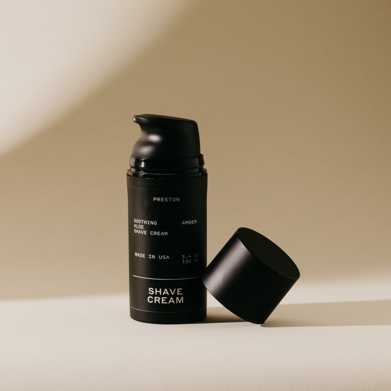 Black pump bottle of Preston soothing aloe shave cream with cap removed