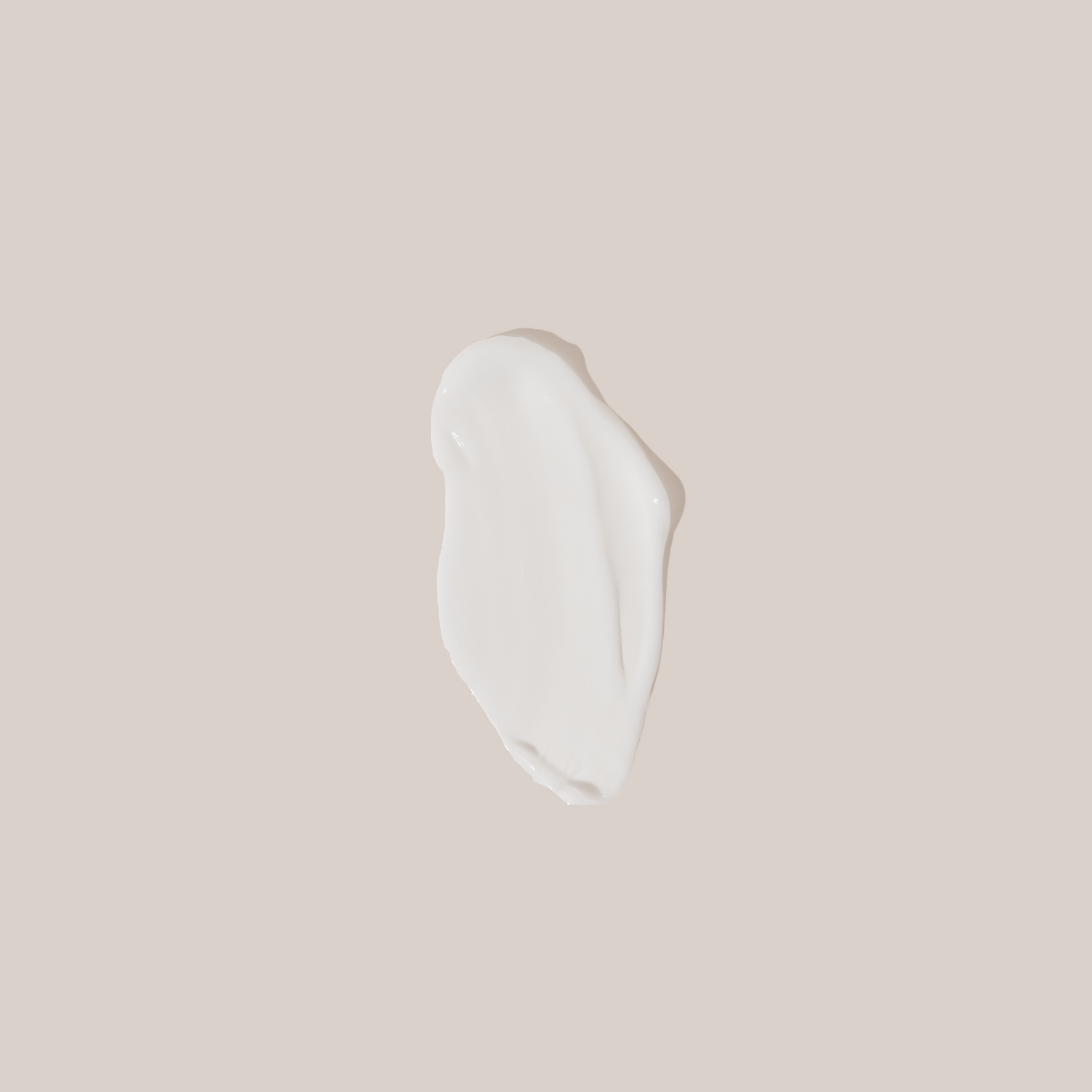 White cream smear on a beige background