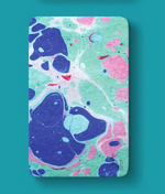 Marbled paper texture showcasing fluid swirls of deep blue, bright pink, and pastel green on a white ground