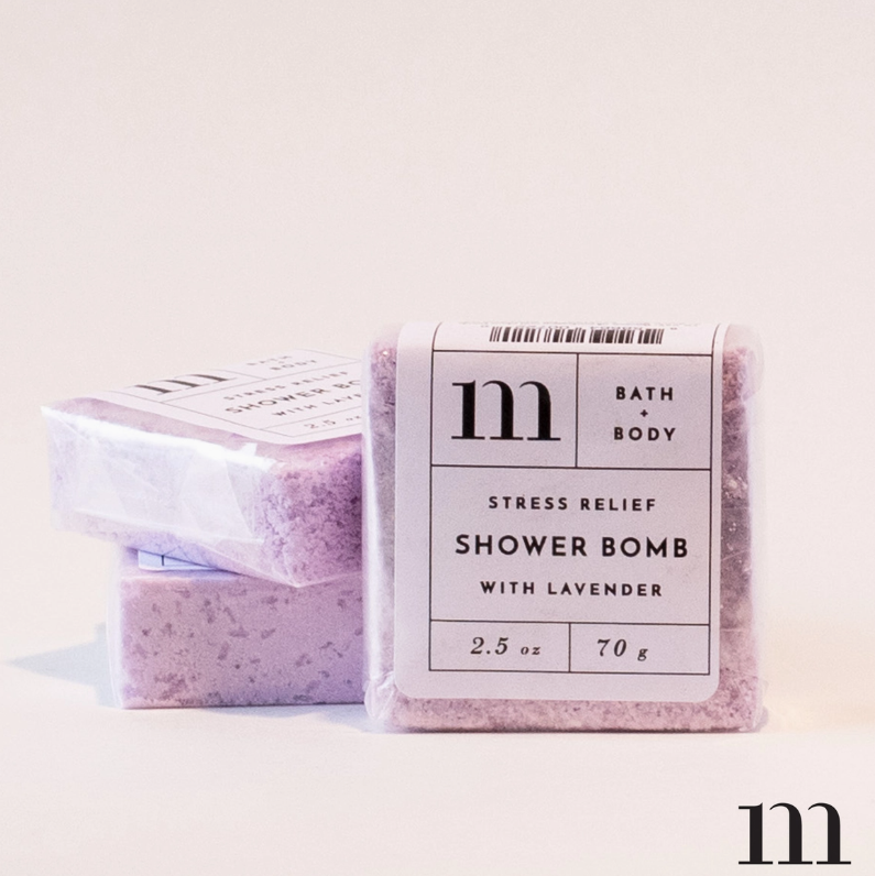Three m Bath + Body Stress Relief Shower Bombs in a studio shot, showcasing their soft lavender color and white labels with black text for 'Stress Relief' and '2.5 oz'