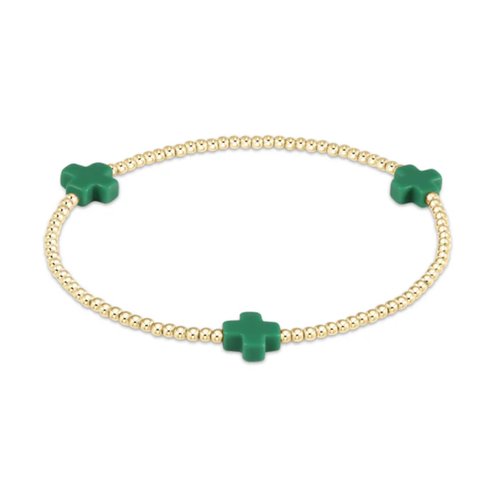 Gold beaded bracelet with three vivid green cross-shaped charms
