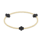 Gold beaded stretch bracelet featuring three matte black quatrefoil cross charms on a white background