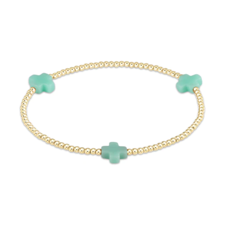 Jewelry: Delicate gold beaded bracelet adorned with three mint green cross-shaped charms