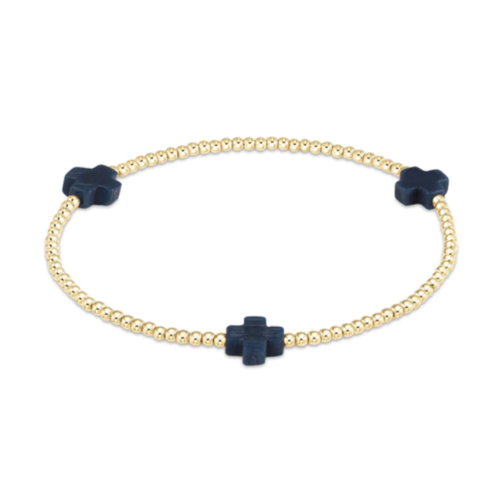 Gold beaded stretch bracelet featuring three dark blue cross-shaped charms on a white background