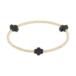 Gold beaded bracelet featuring three matte black cross-shaped charms displayed against a plain white background