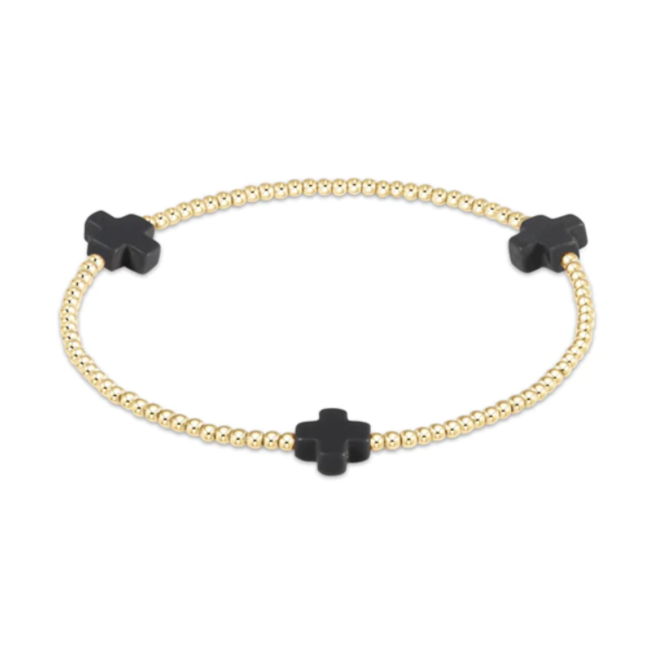 Gold beaded bracelet featuring three matte black cross-shaped charms displayed against a plain white background
