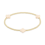 Gold-toned beaded stretch bracelet with three pale pink cross-shaped charms