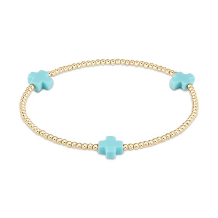 Dainty gold beaded bracelet featuring three vibrant turquoise cross charms
