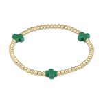 Gold-toned stretch bracelet featuring numerous spherical beads and three vibrant green cross-shaped charms