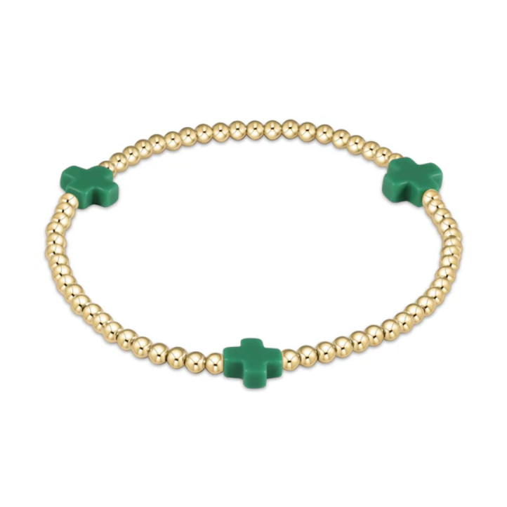 Gold-toned stretch bracelet featuring numerous spherical beads and three vibrant green cross-shaped charms