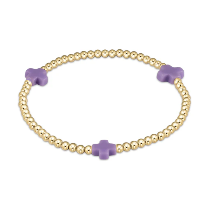 Jewelry: a gold beaded stretch bracelet adorned with three small lilac cross-shaped beads