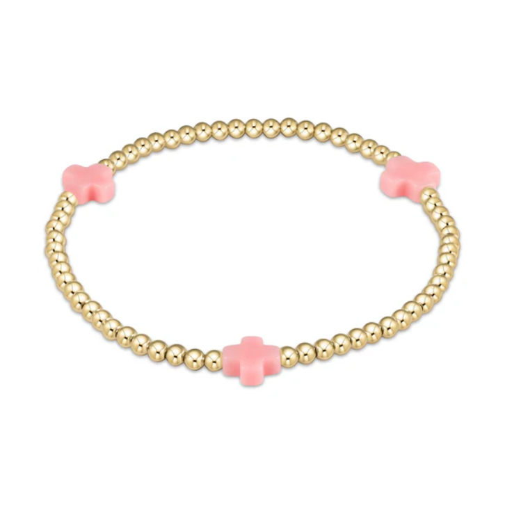 A delicate gold beaded bracelet featuring three evenly spaced pastel pink cross-shaped accents