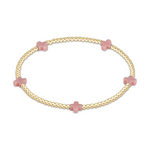 Gold beaded bracelet with four pink cross shaped beads