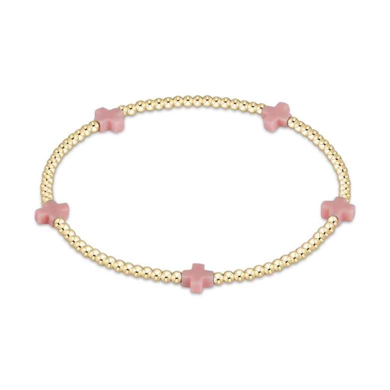 Gold beaded bracelet with four pink cross shaped beads