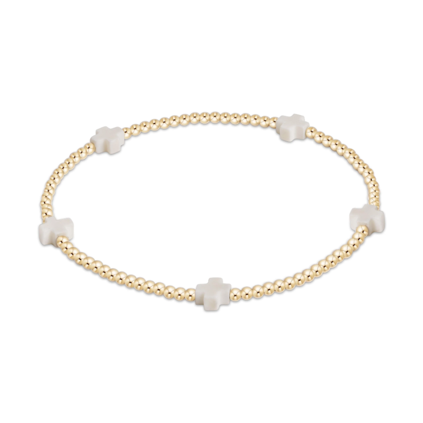 Gold beaded stretch bracelet with four white cross charms