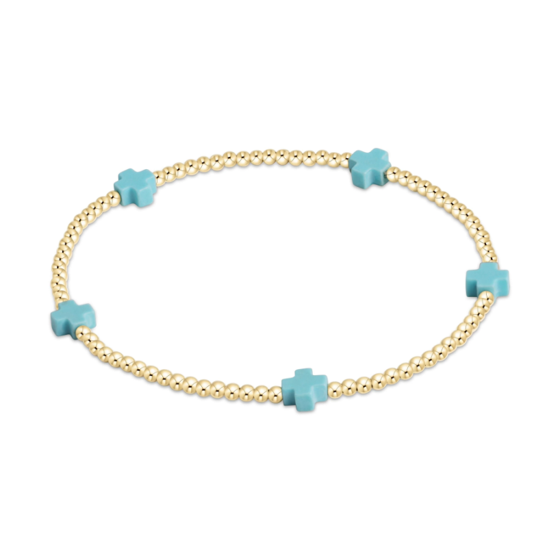 Gold bead bracelet with four light blue cross shaped beads