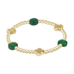 Gold beaded bracelet featuring three faceted dark green oval gemstones and three gold four-leaf clover charms on a white background