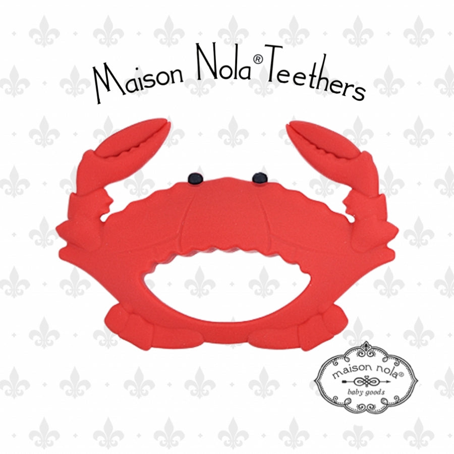 Maison Nola Teethers digital product image featuring a vibrant red silicone crab teether with distinct black eyes against a white background adorned with a subtle grey fleur-de-lis pattern