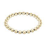 A stretch beaded bracelet featuring alternating large shiny gold-tone spheres and smaller dark grey beads arranged in an oval shape