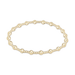 A minimalist gold beaded bracelet featuring a pattern of alternating larger and smaller round, polished beads