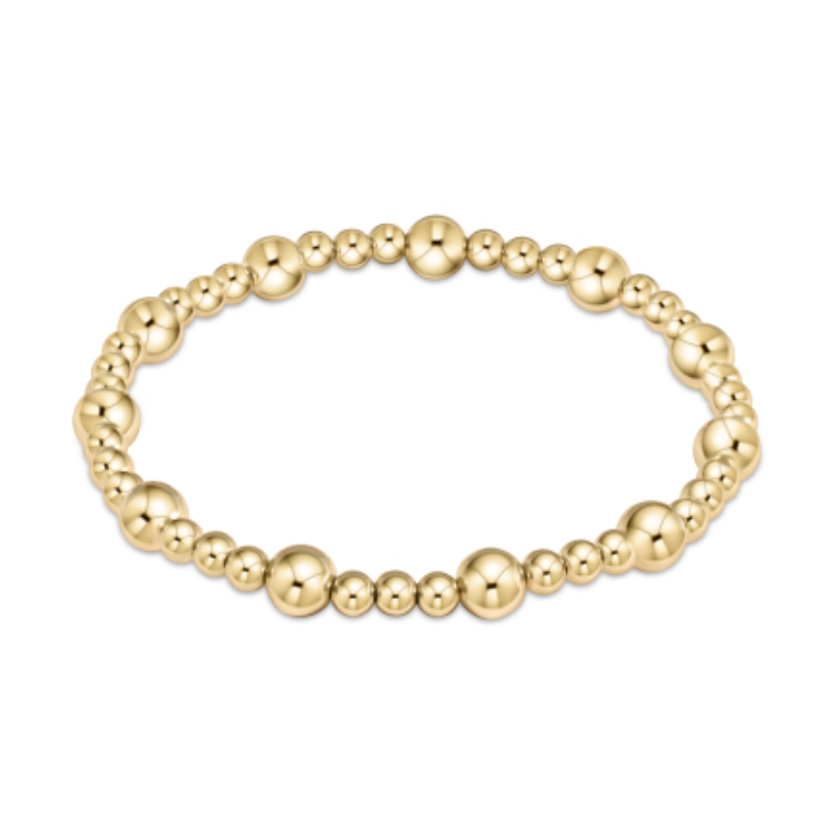 A polished gold beaded stretch bracelet featuring alternating large and small beads on a clean white background