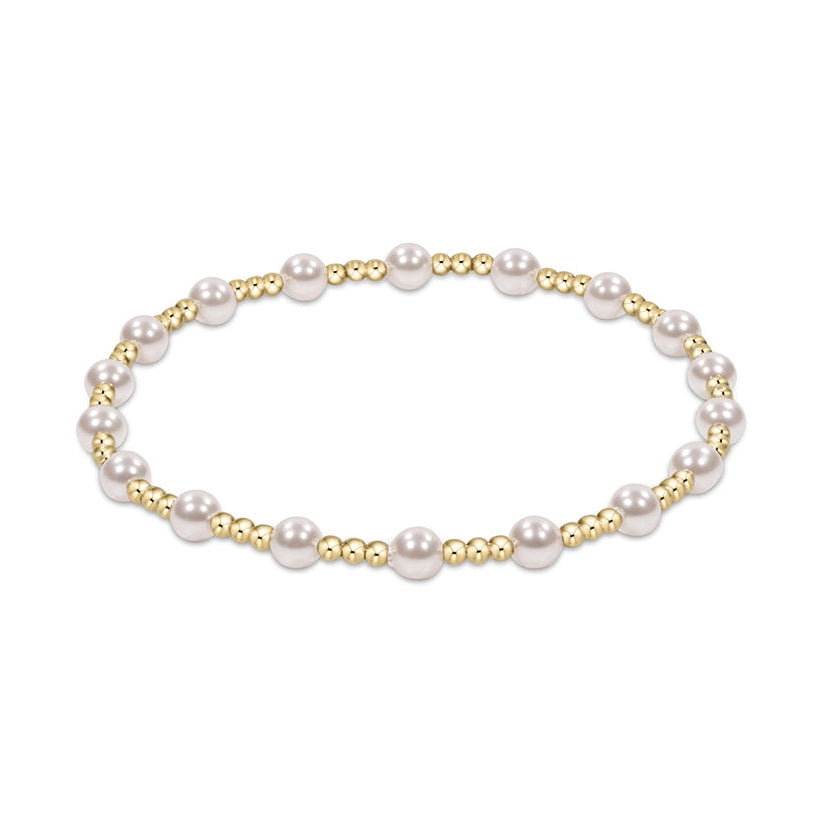 Stretch bracelet featuring alternating white pearls and small gold beads