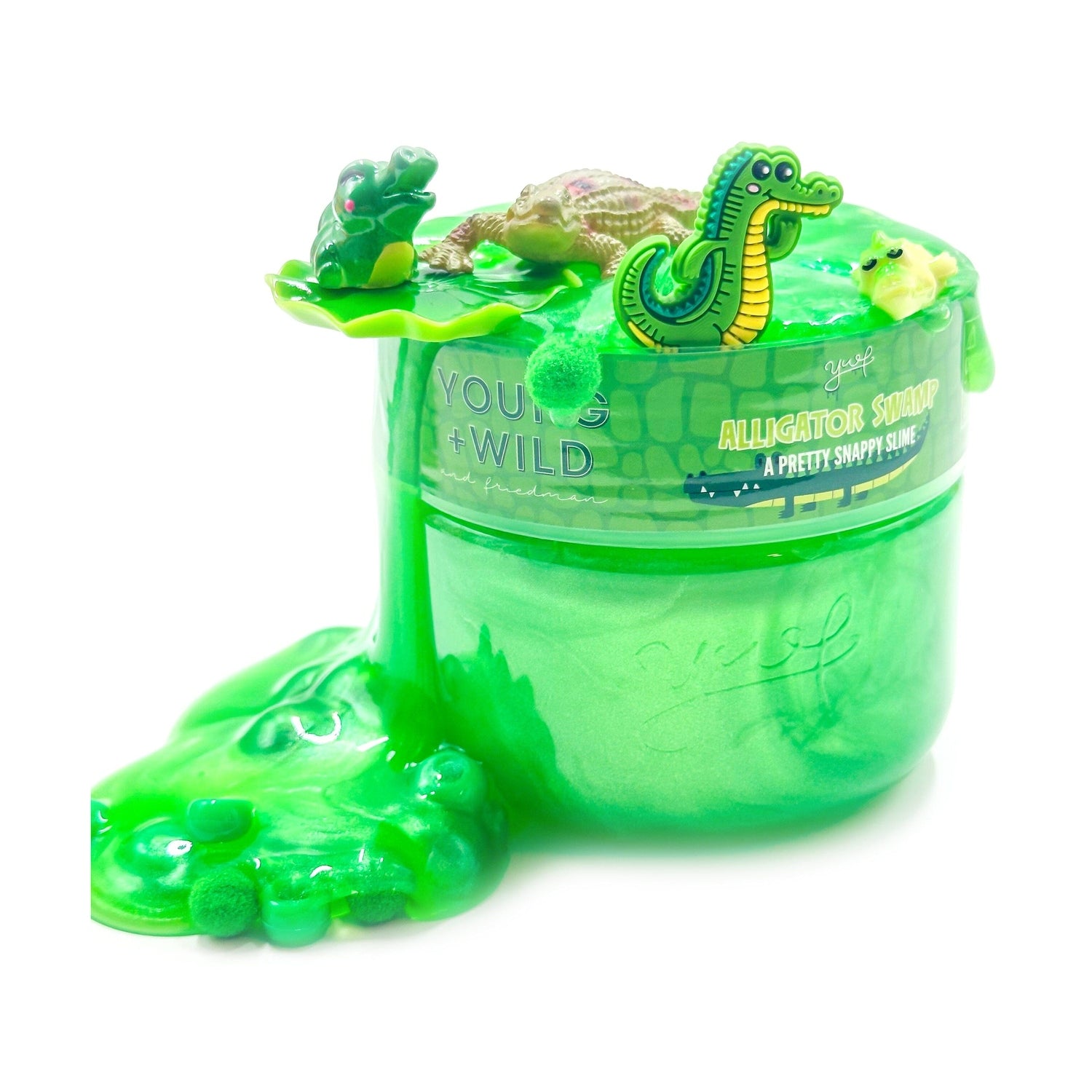 Product photo of Yoof Alligator Swamp A Pretty Snappy Slime, a vibrant green glittery slime overflowing a clear jar on a white background, featuring small alligator and frog figures and green fuzzy balls