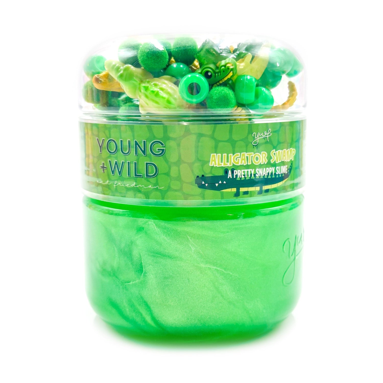 Young + Wild Alligator Swamp Slime in a clear two-tiered container featuring vibrant green shimmery slime, fuzzy green pom-poms, and tiny alligator figures on a white studio background
