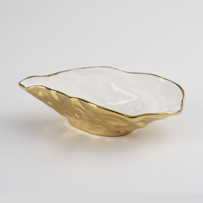 Ceramic decorative bowl in an organic wavy shape featuring a textured metallic gold exterior with a glossy white interior and gold rim
