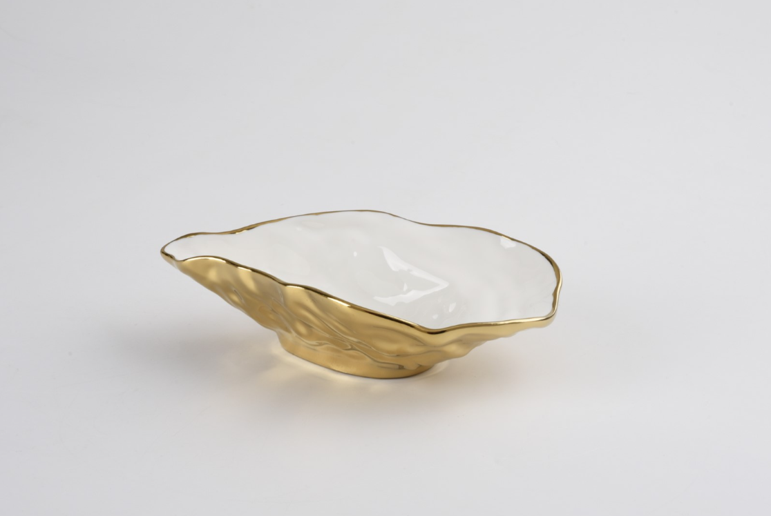 Ceramic oyster-shaped decorative bowl set against a neutral white studio background featuring a textured metallic gold-plated exterior and a smooth polished white interior with a gilded rim