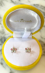 Photograph of delicate gold butterfly stud earrings with pink and white enamel wings presented in an open bright yellow velvet Jack and Jewelz jewelry box with a white satin lining