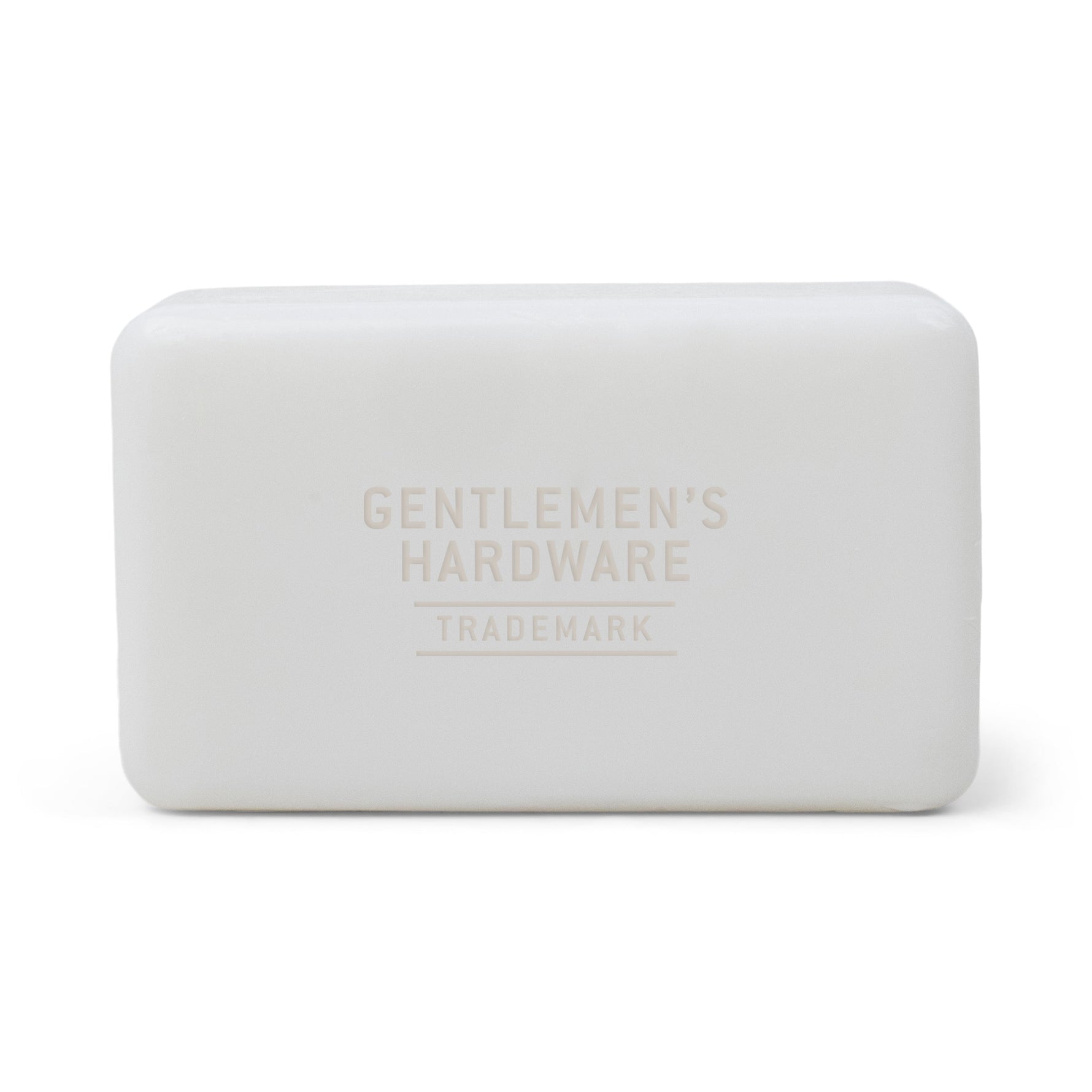 Photograph of a smooth matte white rectangular bar of soap with rounded edges, embossed with Gentlemen's Hardware Trademark text centered on its surface