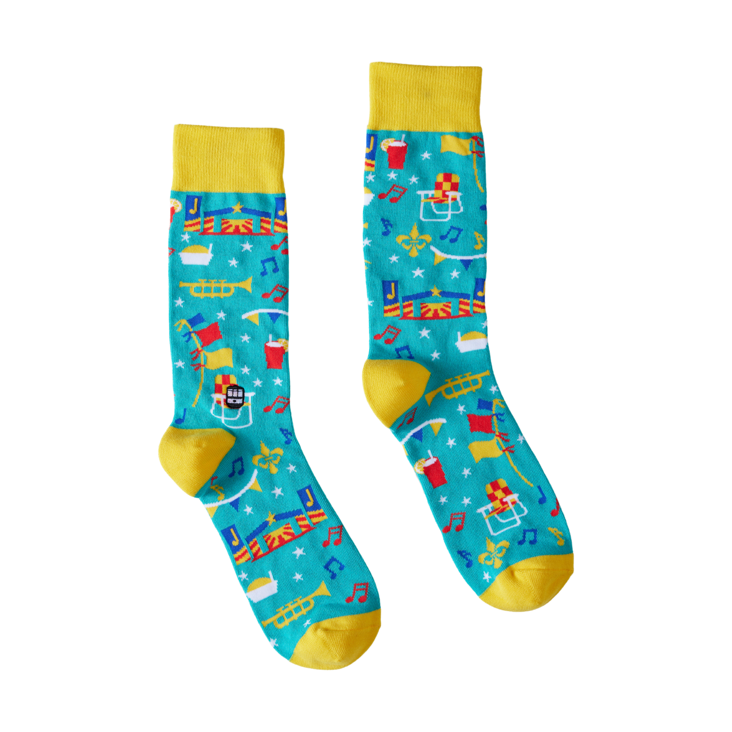 Textile socks depicting a vibrant New Orleans scene with Jackson Square, a streetcar, fleur-de-lis, musical notes, and a football helmet, set against a teal background with yellow cuffs and heels