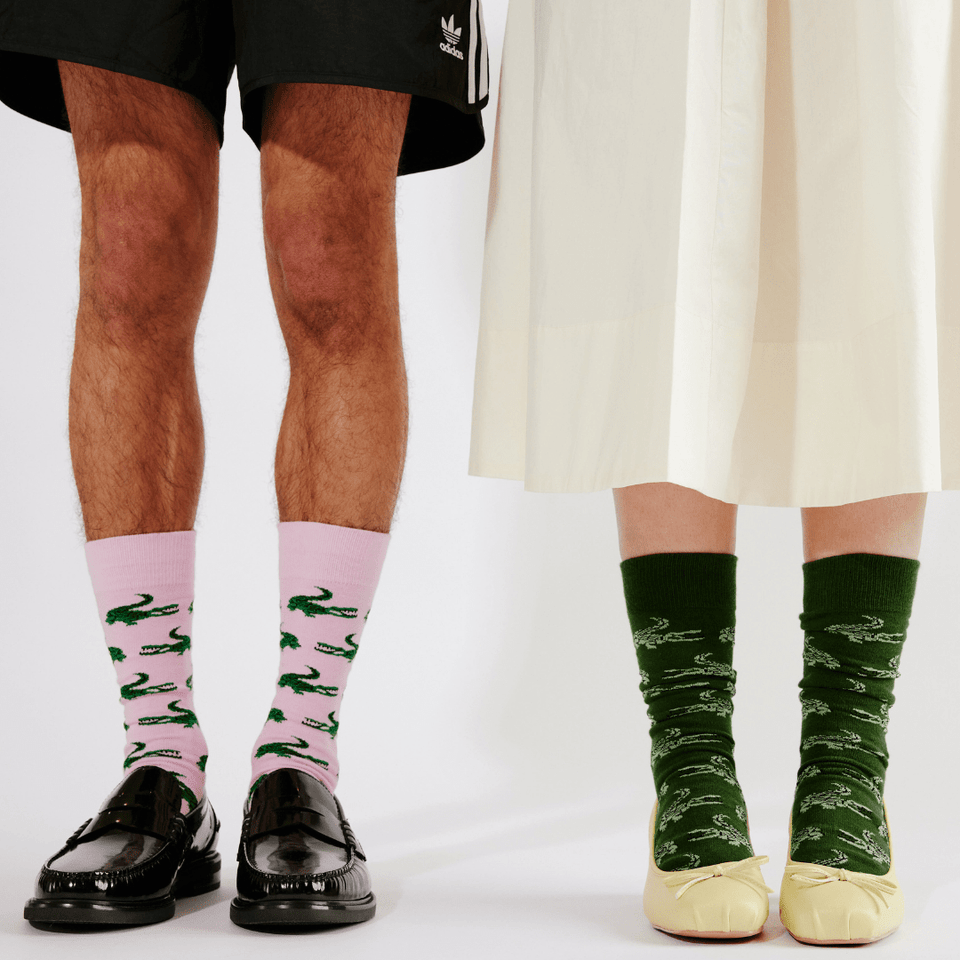 Two people wearing patterned crew socks with black loafers and light yellow ballet flats