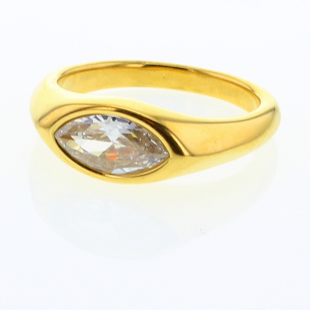 Photograph of a sleek polished yellow gold ring featuring a brilliant marquise-cut clear diamond set flush into a sculptural tapered band reflecting on a white surface