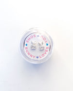 Silver bunny shaped stud earrings with clear stones in a round plastic container