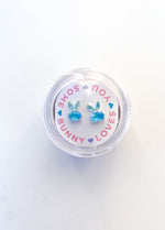 Blue gemstone bunny shaped stud earrings in a circular display box