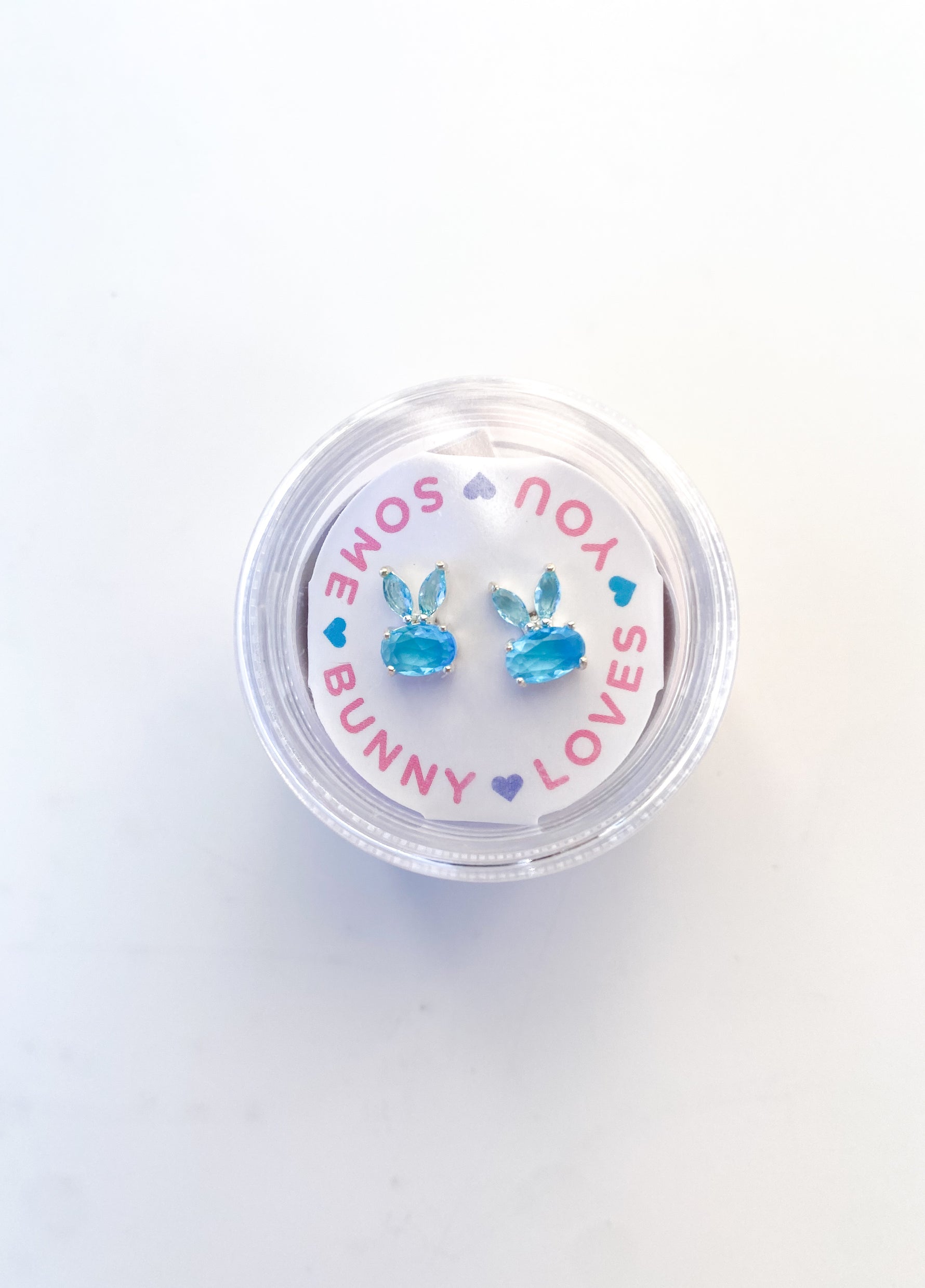 Blue gemstone bunny shaped stud earrings in a circular display box