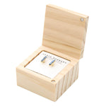 Product photograph showing Santa Barbara Design Studio gold stud earrings with light blue baguette-cut gemstones presented on a white card inside an open light wood hinged box with a magnetic closure