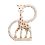 Rubber teether by Sophie la Girafe of a white giraffe with brown spots and pink cheeks, featuring two integrated textured rings (one ribbed, one dimpled) and an embossed Sophie la girafe logo on its base, against a white background
