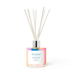 Moodcast SPA RETREAT reed diffuser featuring an iridescent rainbow-colored glass bottle with a silver collar and white reeds on a plain white background