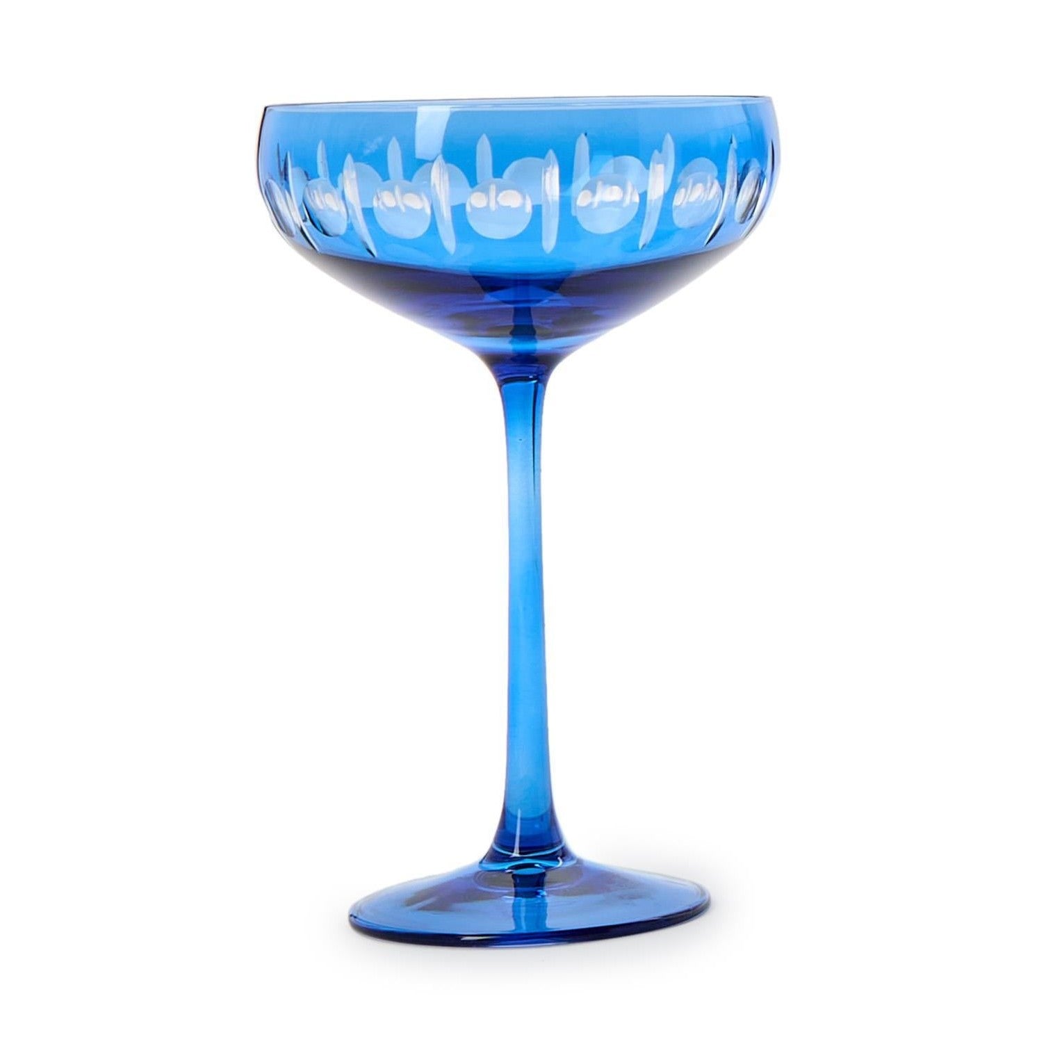Cobalt blue glass champagne coupe featuring a cut glass pattern of circles and vertical lines around its wide bowl