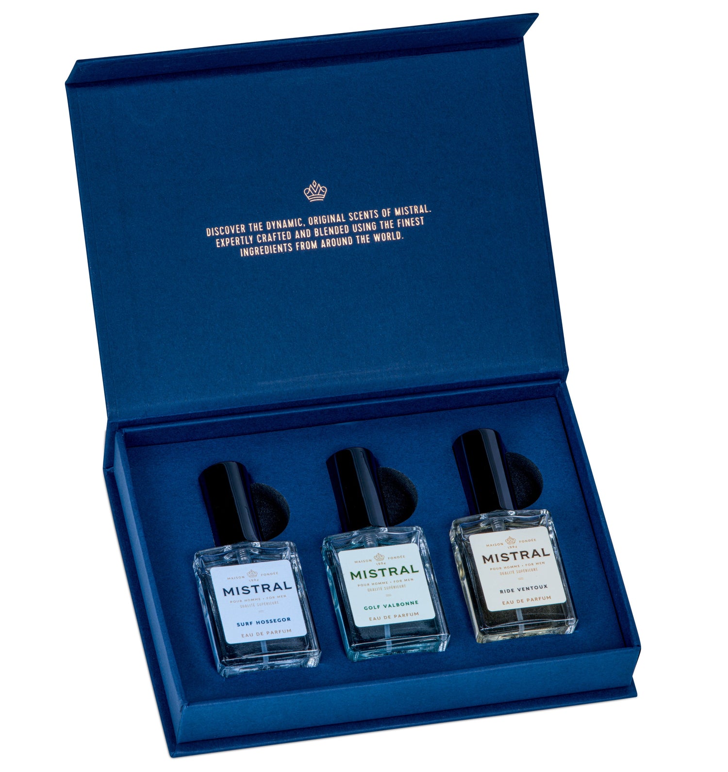Mistral men's fragrance gift set in a luxurious dark blue presentation box, featuring gold foil text on its inner lid and three clear glass bottles with black caps for Surf Hossegor, Golf Valbonne, and Ride Ventoux Eau de Parfum