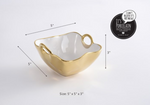 Pampa Bay porcelain serving bowl with an organic wavy gold exterior and white interior, featuring two integrated loop handles and a metallic "I can't believe it's not metal" finish, measuring 5x5x3 inches