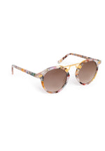 Product photograph of round sunglasses featuring multicolor confetti-patterned acetate frames, a distinctive gold metal bridge, and brown gradient lenses on a clean white studio background