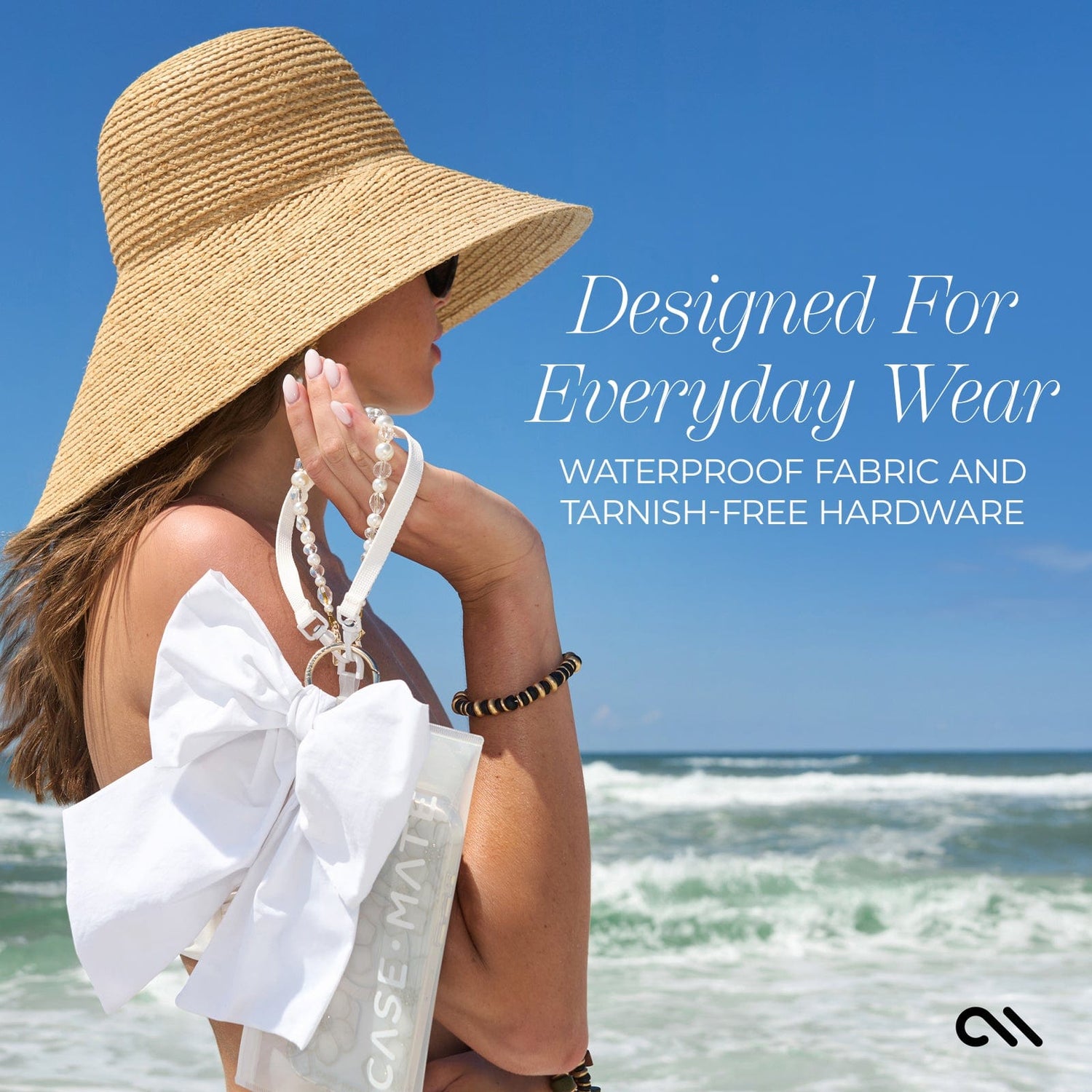 Woman wearing a straw hat and holding a white wristlet accessory at the beach