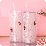Two glass can cups with white speckled pattern and strawberry decals with lids and glass straws