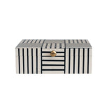 A stylish rectangular decorative box featuring bold black and white geometric stripes and a polished brass knob