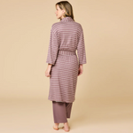 Digital studio photograph of a woman viewed from behind wearing a dusty rose and white horizontal-striped robe with a cinched waist and matching solid lounge pants against a neutral tan studio backdrop