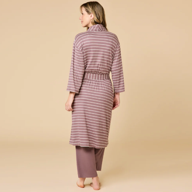 Digital studio photograph of a woman viewed from behind wearing a dusty rose and white horizontal-striped robe with a cinched waist and matching solid lounge pants against a neutral tan studio backdrop
